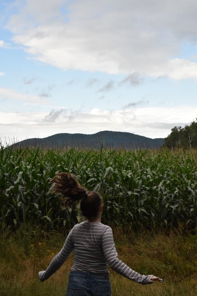 Jugendliche in der Natur läuft auf ein Feld zu